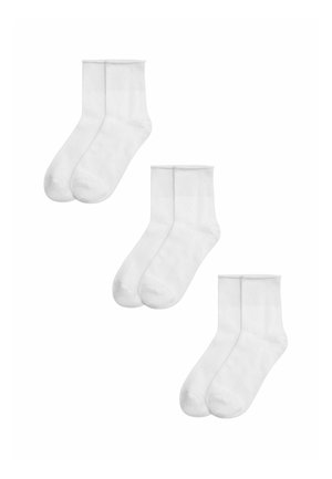 Tres pares de calcetines blancos lisos hasta el tobillo, dispuestos en diagonal sobre un fondo blanco.