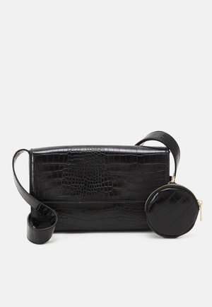 Sac à bandoulière noir en texture embossée crocodile, de forme rectangulaire et avec une sangle ajustable, accompagné d'une petite pochette ronde.