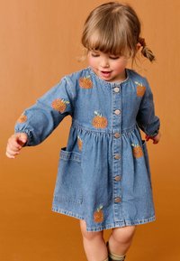 Denim jurk met lange mouwen, voorzien van borduursel van sinaasappelvruchten, knoopsluiting aan de voorkant en een geraffineerde taille. Inclusief zijzakken. Blauwe kleur.