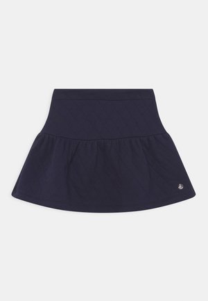 Marineblå quiltet nederdel med en afslappet design og en struktureret overflade. Har en glat talje og et lille logo i kanten.