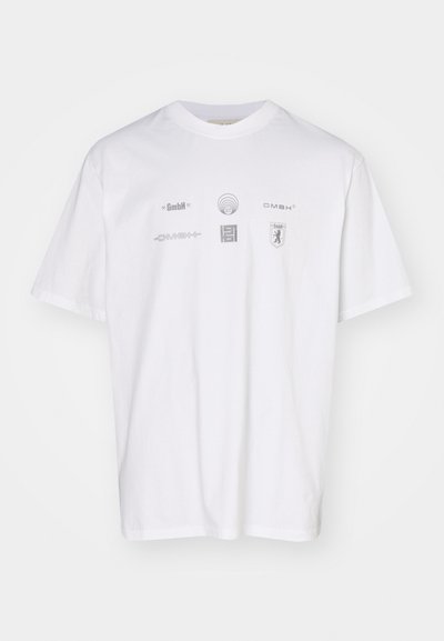 Weißes Baumwoll-T-Shirt mit mehreren silbernen Logos und Designs auf der Vorderseite, darunter "GmbH" und abstrakte Formen. Kurze Ärmel, lockere Passform.