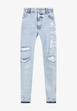 Světle modré džíny z denimu s distressed detaily, včetně protržení a záplat. Texturovaná látka s rovnými nohavicemi a zapínáním na knoflík.