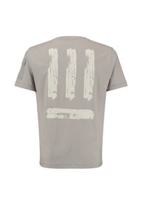 Camiseta de manga corta gris claro con tres impresiones verticales y una horizontal de brochazos blancos desgastados en la parte posterior y un bolsillo en la manga izquierda.