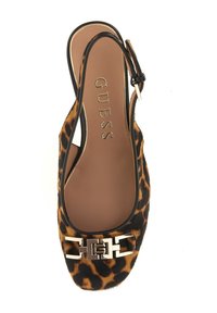 Slingback-schoen met luipaardprint, een afgeronde teen, zwarte afwerking en metalen gespsdetail. Zacht textuur met een platte zool. Merkennaam "GUESS" geperst aan de binnenkant.