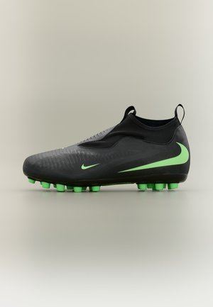Čierne futbalové kopačky s neónovo zeleným logom Nike a kolíkmi, so slip-on dizajnom, pútkami na členku a textúrovaným zvrškom.