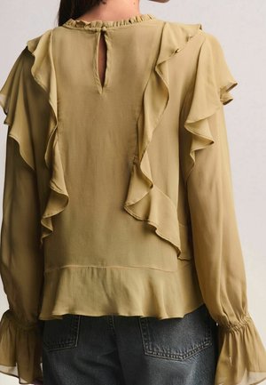 Blouse vert olive avec accents à volants, manches longues, dos fendu en forme de clé et tissu doux et léger. Caractérisée par des poignets froncés et un ourlet évasé.