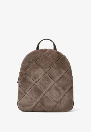 Sac à dos en fausse fourrure marron avec un motif matelassé, de forme ronde, doté d'une poignée supérieure et d'accents noirs contrastants sur le fond et la fermeture éclair.