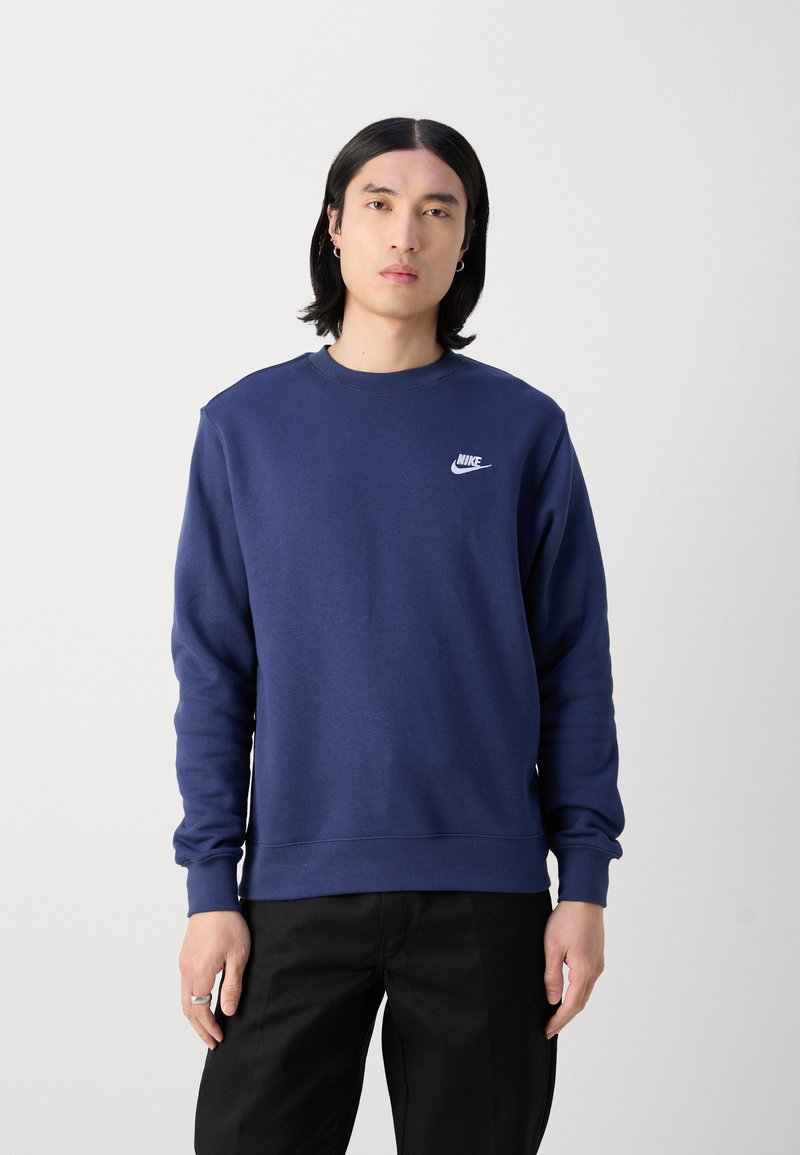 Mörkblå Nike sweatshirts med långa ärmar, rundad halsringning, ribbade muddar och en liten vit logotyp på vänster bröst. Tillverkad av bomullsblandat material.