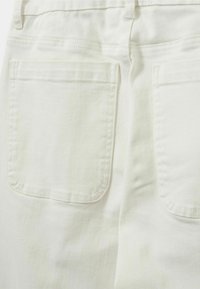 Valkoiset farkut, joissa on kaksi takataskua, sileä pinta, kaksoisompeleita ja normaali vyötärön muotoilu.