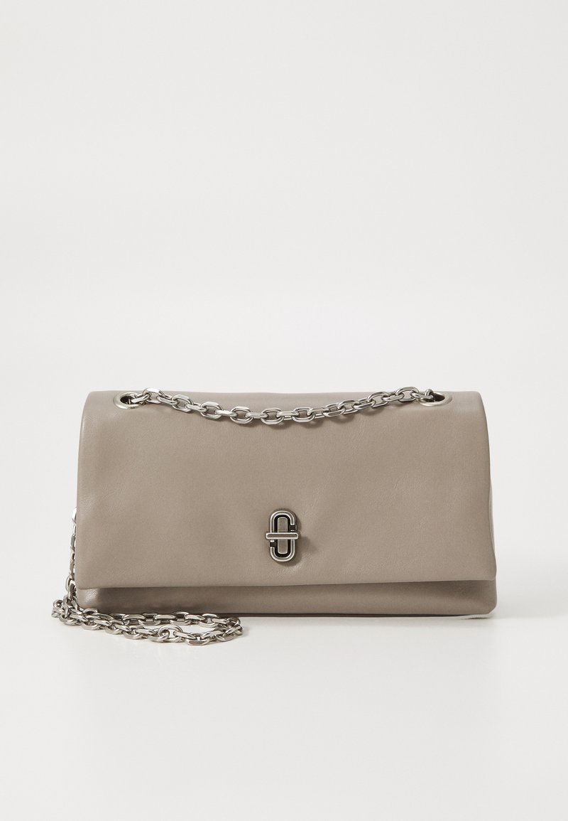 Taupe leather handbag with a fold-over design, silver chain strap, and a front clasp featuring a circular accent. Smooth texture.