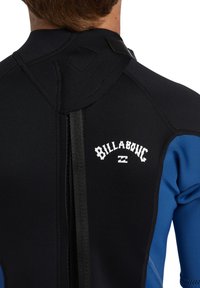 Czarny i niebieski pianka z gładką teksturą, zamek błyskawiczny z tyłu i logo "Billabong". Posiada wzmocnione szwy i elastyczny design.