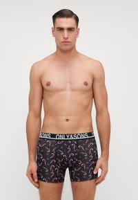 Boxer neri con stampa di bastoncini di zucchero, con vita elasticizzata che presenta il testo "ONLY&SONS", di lunghezza media che si ferma sopra la coscia.