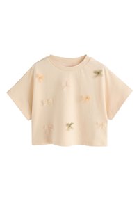 Haut court à manches courtes couleur pêche avec un col arrondi, orné d'appliqués de petits nœuds pastel dispersés en rose, jaune et vert.