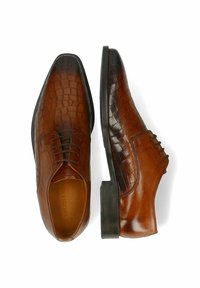 Chaussures en cuir marron avec un motif texturé de crocodile sur un côté, une finition lisse de l'autre, et une semelle en caoutchouc noir plate.