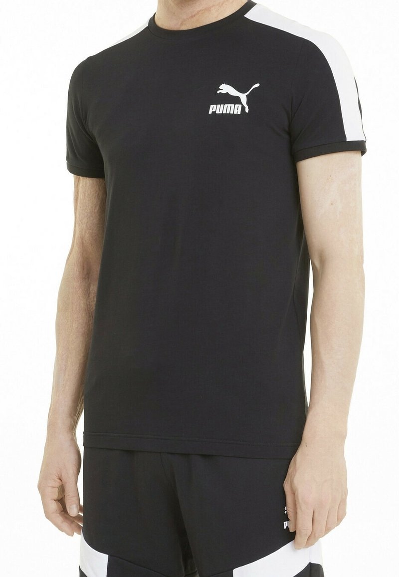 Black short-sleeve T-shirt made of cotton blend, featuring white shoulder accents and a small white Puma logo on the chest.