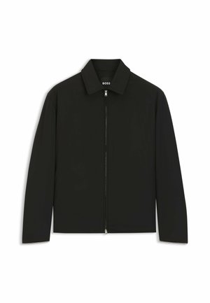 Veste légère noire avec une fermeture éclair intégrale à l'avant et un col classique, présentée sur un fond blanc.
