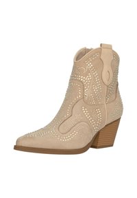 Bota de tobillo western de ante beige con punta afilada, costuras decorativas y acentos de strass. Presenta un tacón bajo y apilado y un lazo en la parte posterior.