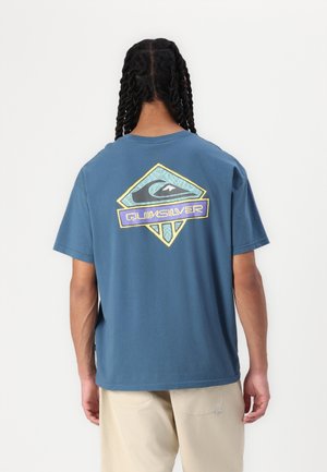 Zila kokvilnas T-krekls ar krāsainu Quiksilver logo grafiku mugurā, ar brīvu piegriezumu un īsām piedurknēm.