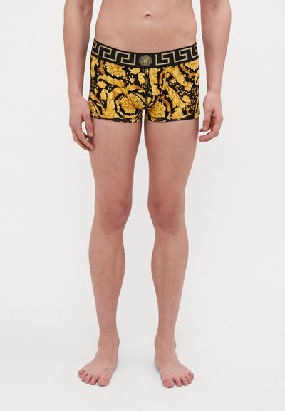 Men's boxer briefs with a yellow floral pattern on a black background, featuring a black waistband with a Greek key design.
