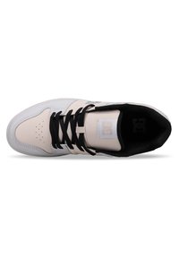 White and light pink sneaker with black laces, perforated toe, padded collar, logo on tongue, and textured upper for grip.