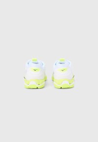 Fehér és világoskék sportcipők texturált felsőrésszel, neon sárga kiegészítőkkel és gumi talppal, hátul húzófülekkel könnyű felvételhez.