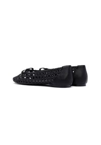 Bailarinas negras con un upper trenzado con un patrón texturizado y acentos de cuero negro en el tacón, diseñadas para la comodidad y la transpirabilidad.
