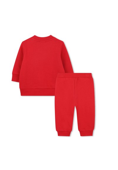 Ensemble de survêtement en coton rouge composé d'un haut à manches longues avec des poignets côtelés et d'un pantalon de jogging assorti avec une taille élastique et des chevilles ajustées.