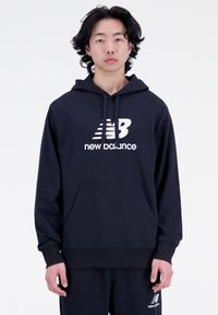 Sudadera de algod�ón azul marino con un bolsillo frontal, logo blanco de "New Balance" y cordones. Presenta un corte relajado y puños acanalados.