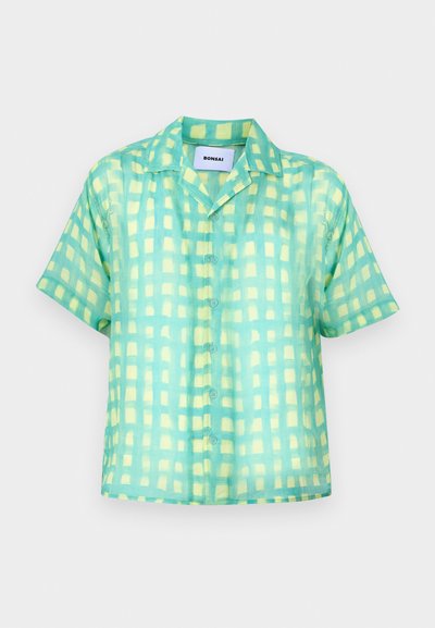 Srajca s kratkimi rokavi in gorgozno zeleno barvo s rumenim kariranim vzorcem. Narejena iz lahkotnega, gladkega materiala, s klasičnim ovratnikom.