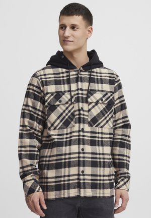 Geklede flanellen shirt in beige en zwart met een capuchon, voorzien van twee borstzakken en een knoopsluiting aan de voorkant. Zacht, gestructureerd stof.