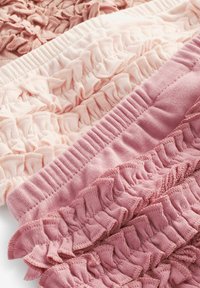 Elastična pletenina u različitim nijansama ružičaste, s ruffles detaljima duž rubova. Glatka tekstura s nabranim detaljima.
