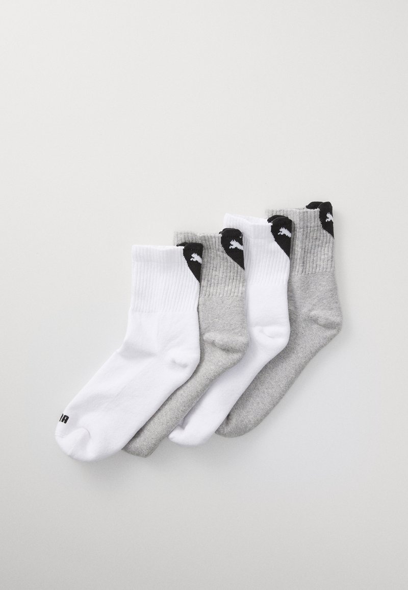 Négy pár legényszesszokni fehér, világosszürke és sötétszürke színben. Pamutból készült, bordázott szájjal és kis fekete logókkal az oldalán.