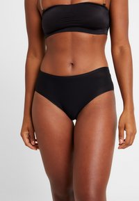 Zwarte high-waisted bikini onderkant gemaakt van een zachte stof, met een naadloos ontwerp en een elastische tailleband voor comfort en pasvorm.