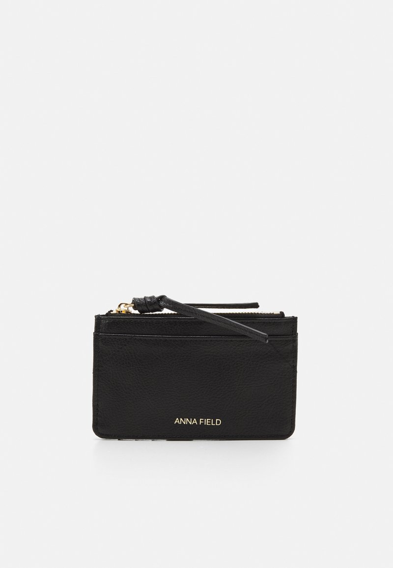 Porta-cartões em couro preto com superfície texturizada, com a marcação a dourado "ANNA FIELD" e um fecho com zip e uma alça correspondente para manuseio seguro.