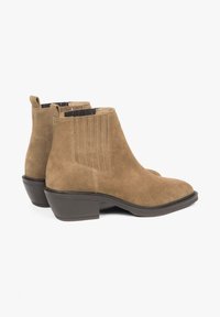 Brown suede ankle boots with a rounded toe, low stacked heel, elastic side panels, and stitched accents on the upper.