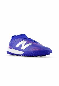 Blue athletic shoe featuring a textured upper, white logo, and contrasting pink dotted pattern, with a rubber sole designed for traction.