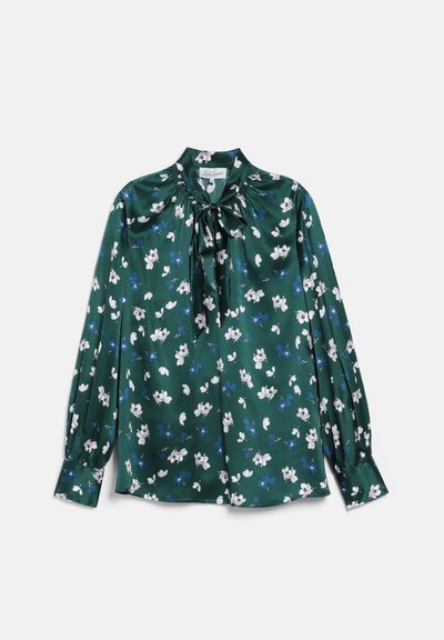 Blouse vert foncé à manches longues avec motif floral blanc et bleu, détail nœud haut de col, et poignets boutonnés, posée à plat sur fond blanc.