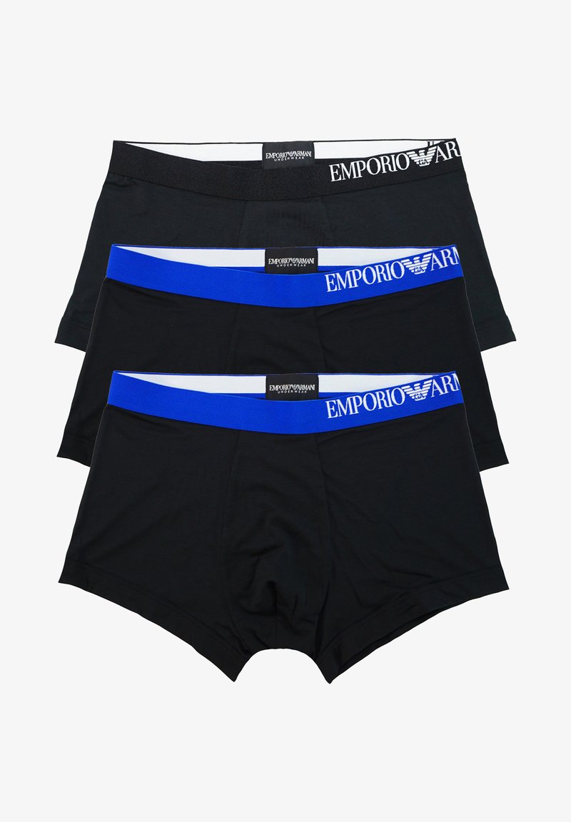 Trois paires de boxers pour hommes : deux noirs avec des ceintures blanches et un bleu avec une ceinture blanche, chacun présentant une marque sur la taille.
