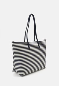 Sac fourre-tout rayé en marine et crème, fabriqué en matériau durable. Dispose de deux longues poignées et d'une fermeture supérieure zippée pour une fermeture sécurisée.