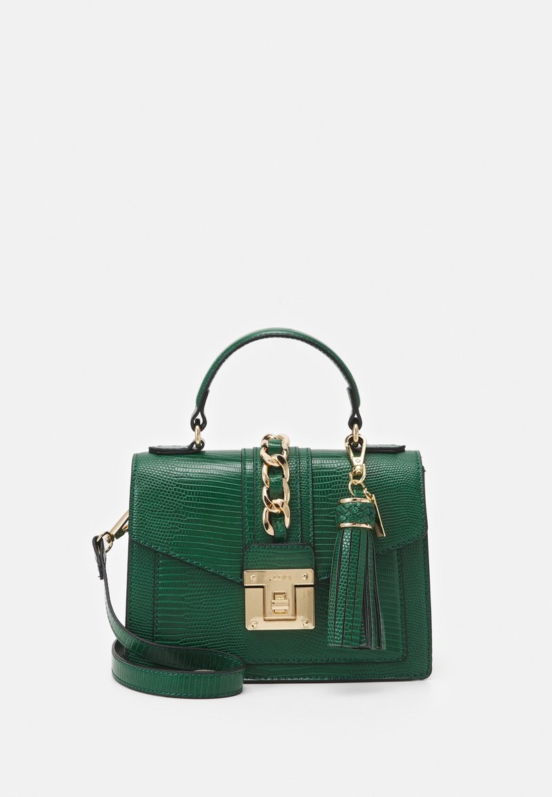 Sac à main en cuir vert texturé avec poignée supérieure, détail en chaîne dorée, ornement à pompon, et fermeture avant à boucle dorée avec bandoulière.