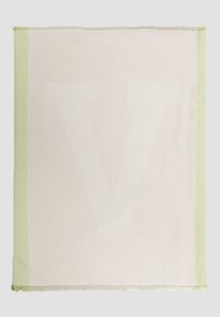 Couverture en coton tissée avec un grand "V" gris clair sur un fond beige, bordée d'un bord en chevron vert texturé et de franges.