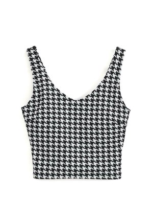Top scurt cu model houndstooth alb și negru, cu bretele largi și un decolteu adânc în V. Fabricat din material elastic, prezintă un model geometric pe toată suprafața.