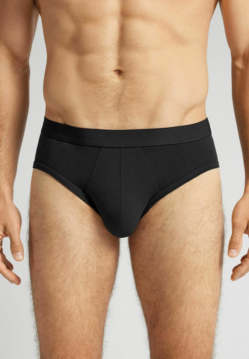 Zwarte katoen onderbroeken met een gladde textuur, voorzien van een brede tailleband en een ontwerp met een pouch aan de voorkant, die een strakke pasvorm benadrukken.