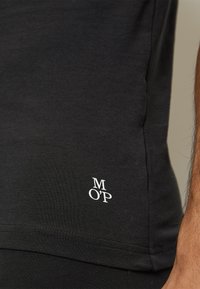 Czarna bawe�łniana koszulka T-shirt z dopasowanym krojem, krótkimi rękawami, szwem bocznym oraz białym haftowanym logo na dolnym brzegu.