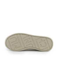 Suola di scarpa in gomma beige chiaro con motivi a spina di pesce e onde. Punta arrotondata e bordi leggermente alzati, che mostrano dettagli di texture e grip.