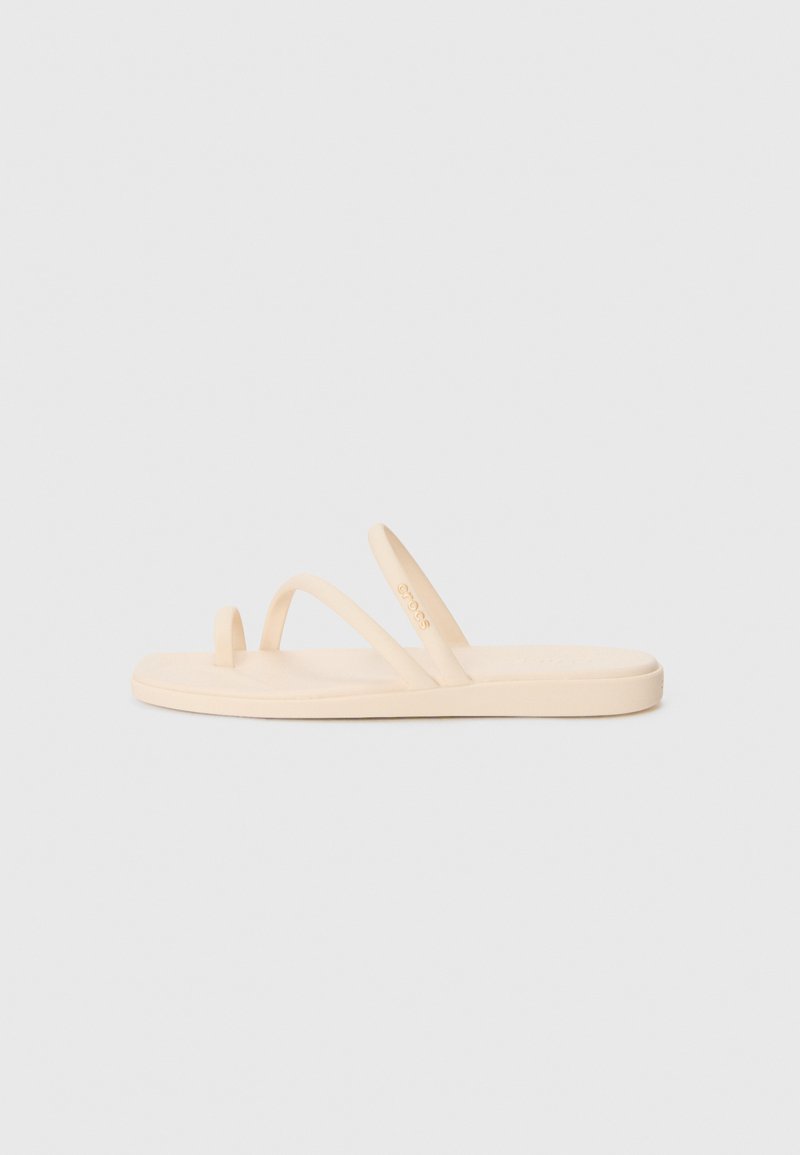 Beige flip-flop sandal with two thin straps and a toe loop, made of soft rubber material, featuring a smooth texture and a flat sole.
