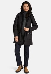 Zwarte geïsoleerde parka met capuchon, ritssluiting en drukknoopsluitingen. Bevat twee voorzakken met klep en contrasterende zilveren ritsen.