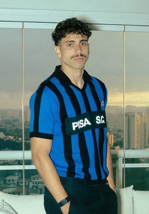 Blauwe en zwarte gestreepte trui met korte mouwen, voorzien van "PISA S.C." in het wit op een zwart label. Eenvoudig kraagontwerp, lichtgewicht stof.