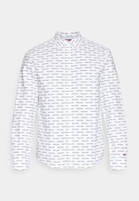 Camicia bianca con bottoni, caratterizzata da un motivo ripetuto di logo nero, colletto classico, maniche lunghe e orlo curvo.