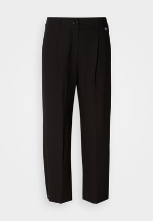 Pantalon noir sur mesure avec une jambe droite, deux plis à l'avant et une fermeture à bouton. Tissu lisse, design minimaliste, sans motifs visibles.